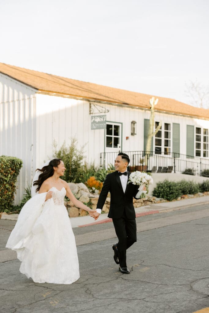 bride and groom running in the street at the secret garden